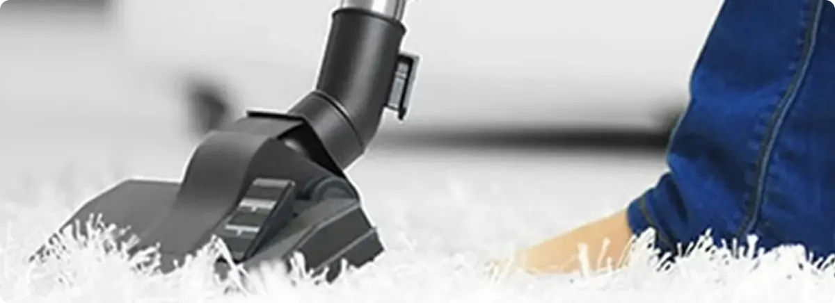Close-up of a professional vacuuming a white carpet in Gardendale.